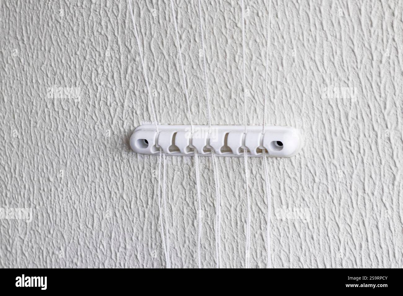 Schnur von der Halterung des Wäschetrockners an der Wand Stockfoto