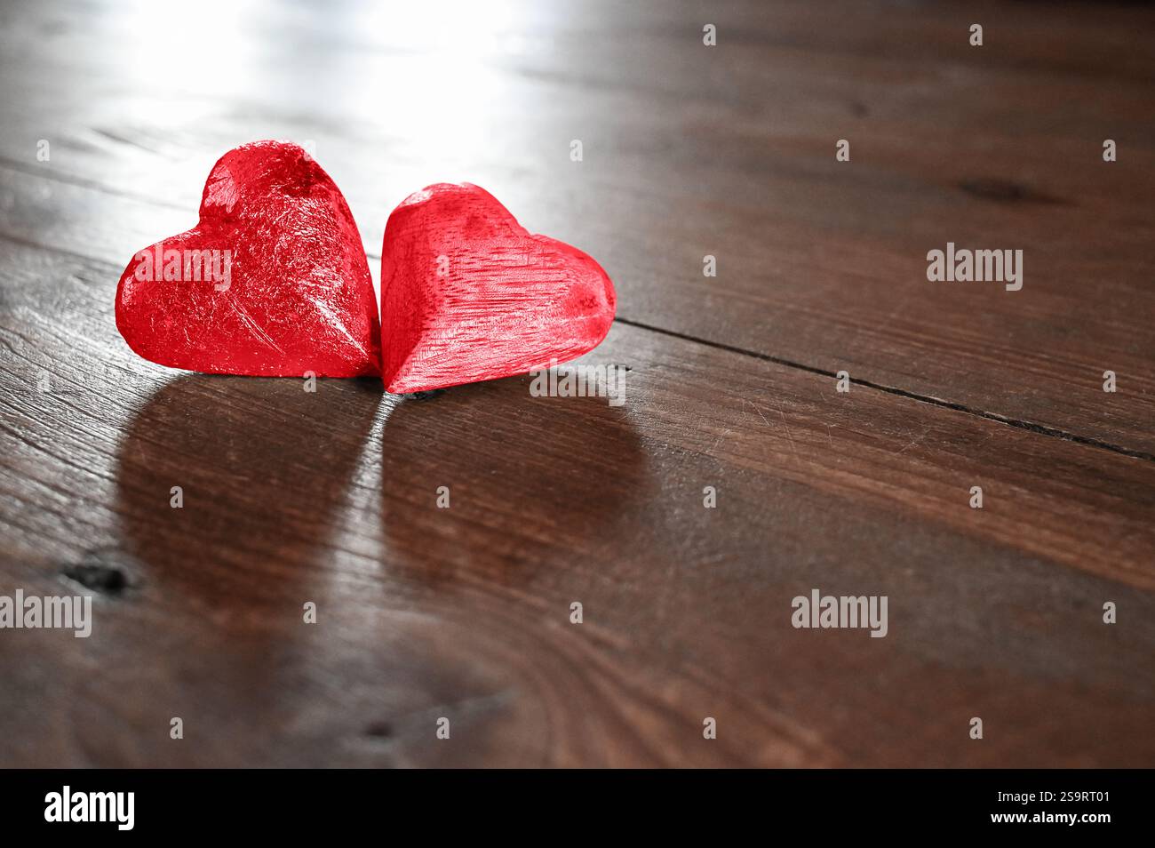 Zwei rote Herzen als ein Paar Liebe auf einem Vintage Holztischboden. Stockfoto