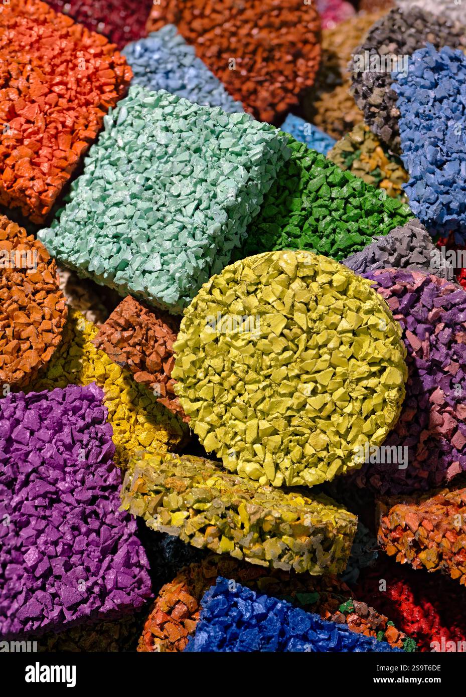 Mehrfarbige Bodenbeläge aus lackierten Gummibröseln, Produkte aus dem Recycling alter Autoreifen. Nahaufnahme, abstrakte geometrische bunte Ba Stockfoto