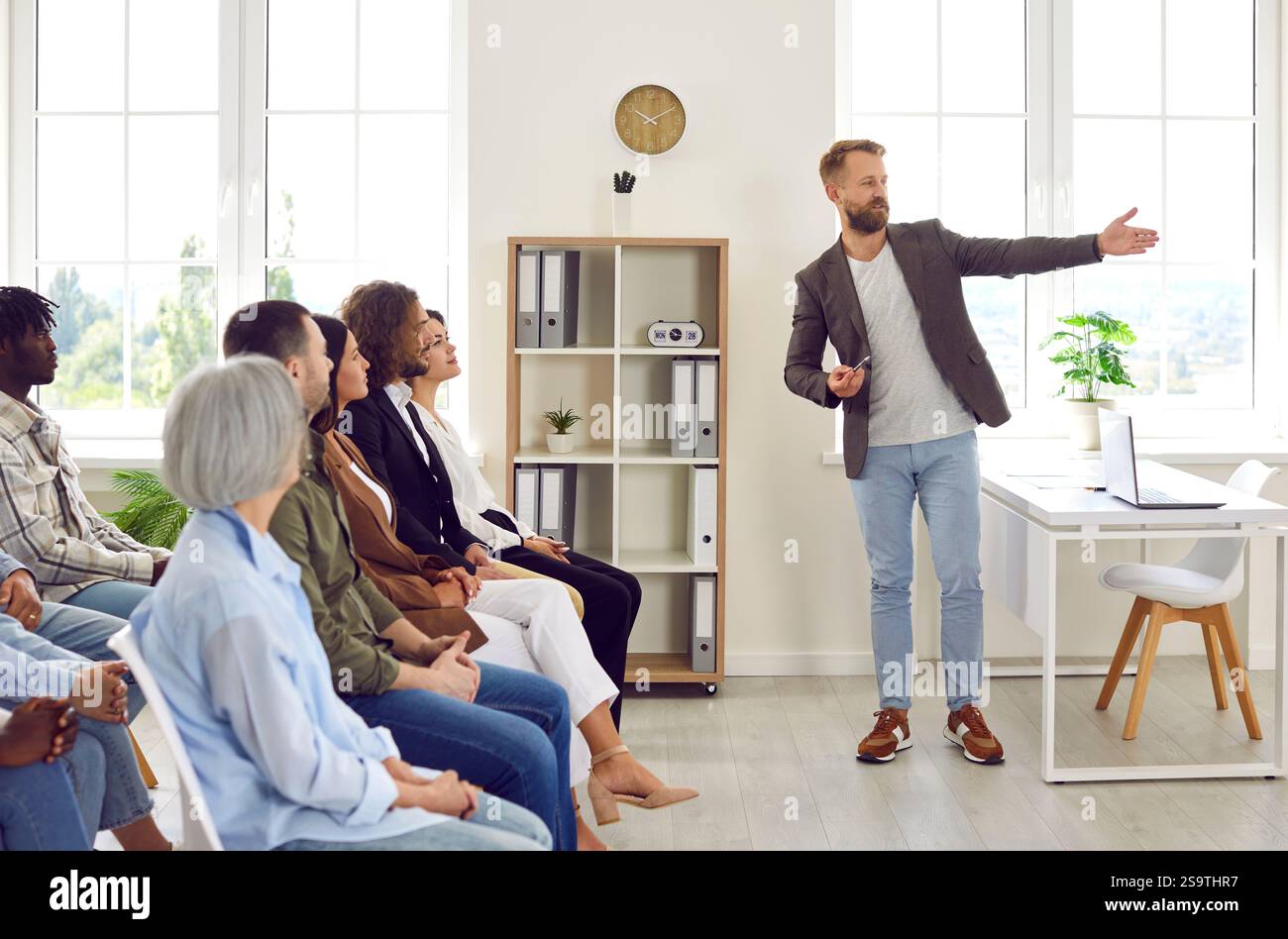 Professioneller Business Coach hält eine Präsentation für ein vielfältiges Publikum im Büro Stockfoto