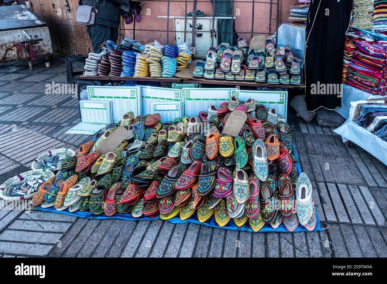 Lebhafte marokkanische Babouche-Hausschuhe werden in der Nähe des Souk in der geschäftigen Medina von Marrakesch zum Verkauf angeboten Stockfoto