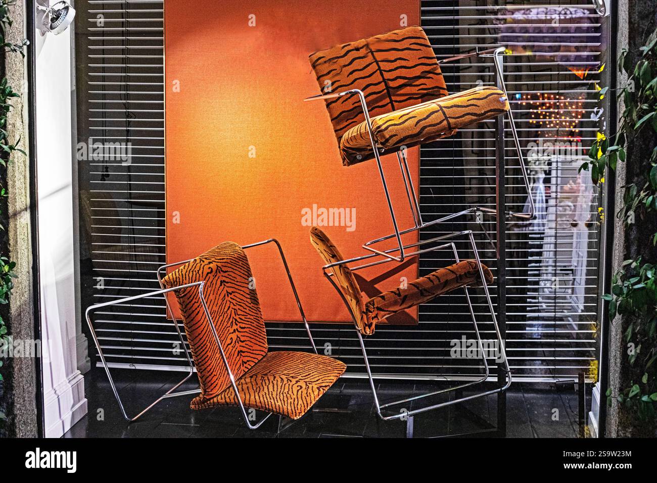 Kreative Fensterverkleidung mit umgedrehten Stühlen Stockfoto