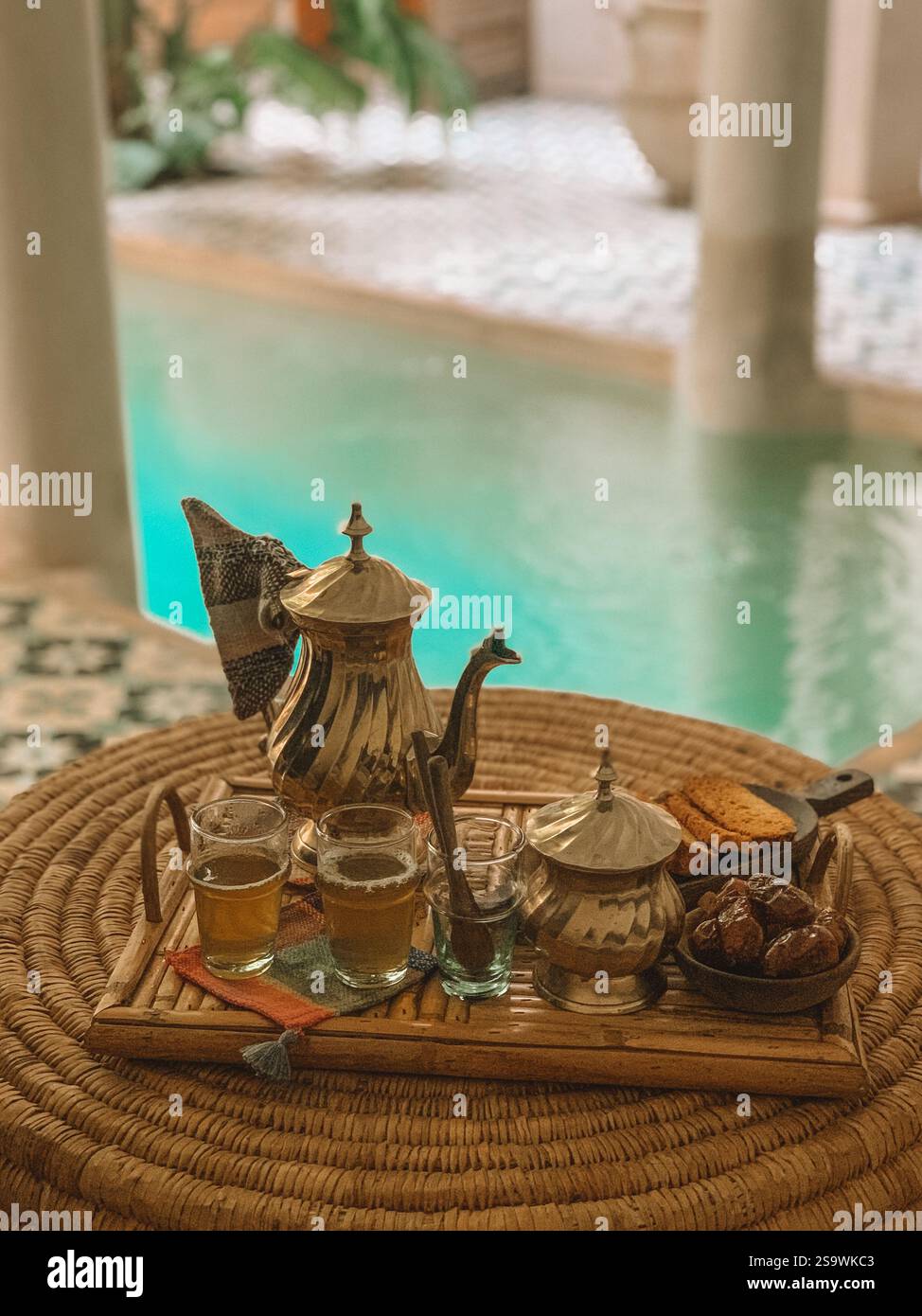 Einladendes Foto von traditionellem marokkanischem Tee, serviert in aufwendig gestalteten Teekannen und Gläsern. Stockfoto