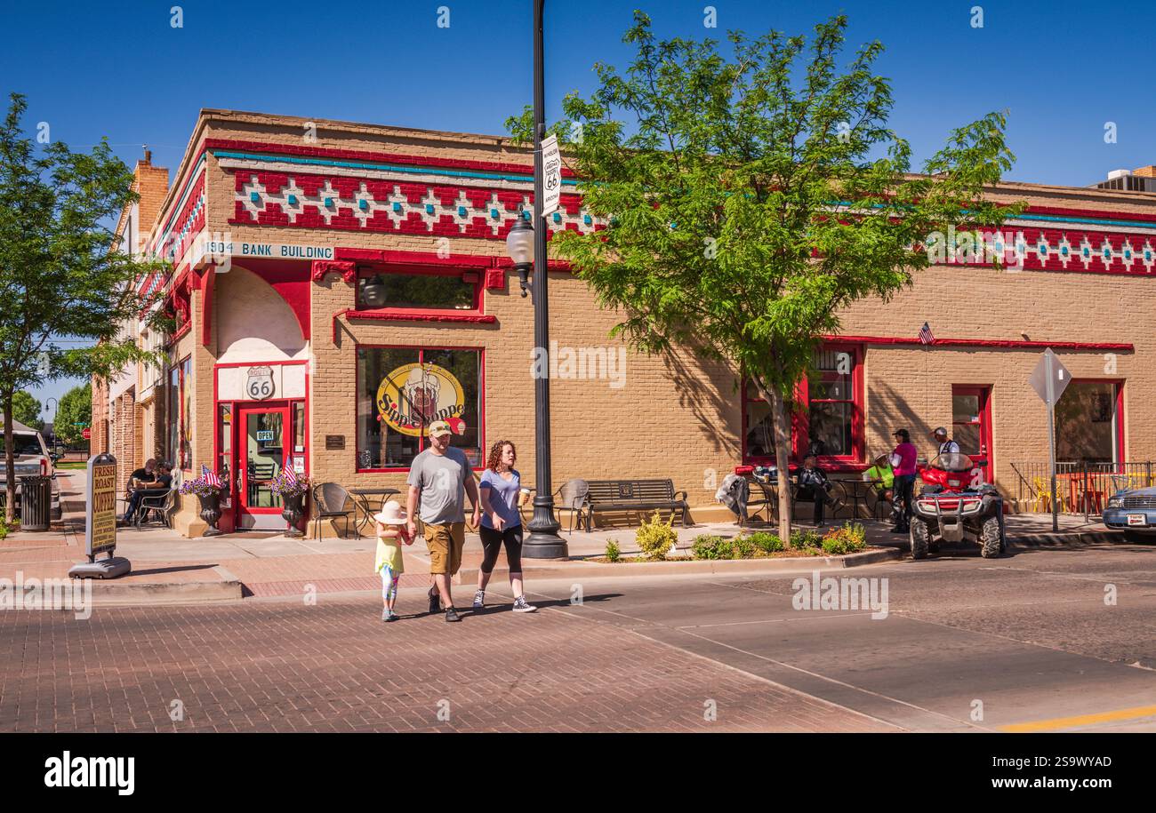 Winslow, AZ USA - 4. Juni 2018: Familie überquert die Straße vor dem SIPP Shoppe, einem Retro-Café in einem historischen Bankgebäude am Standing on the Stockfoto