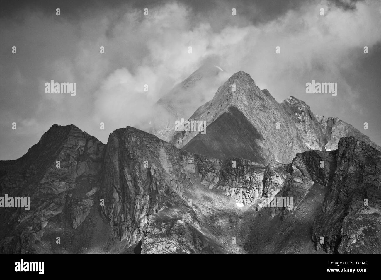 Schwarz-weiße Berglandschaft mit Gipfeln der Daberspitze und Roetspitze (italienisch pizzo rosso) und dramatischen Wolken, hohe Tauern, osttirol, Österreich Stockfoto