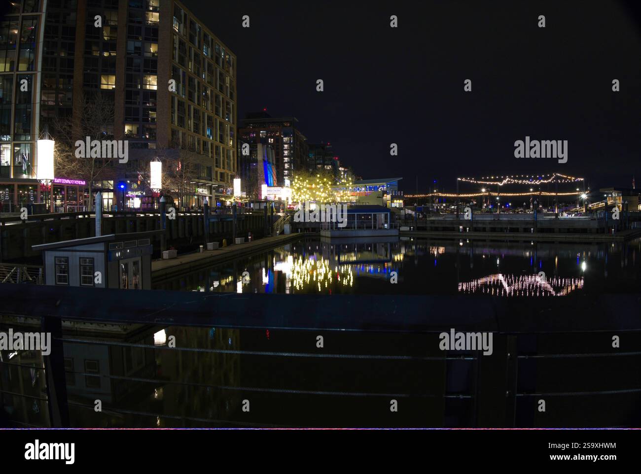 Nächtliches Foto der Wharf-Gegend mit Eislaufbahn und Lichtreflexen. In der Nachbarschaft gibt es Musikveranstaltungen, Restaurants, Geschäfte, etc Stockfoto