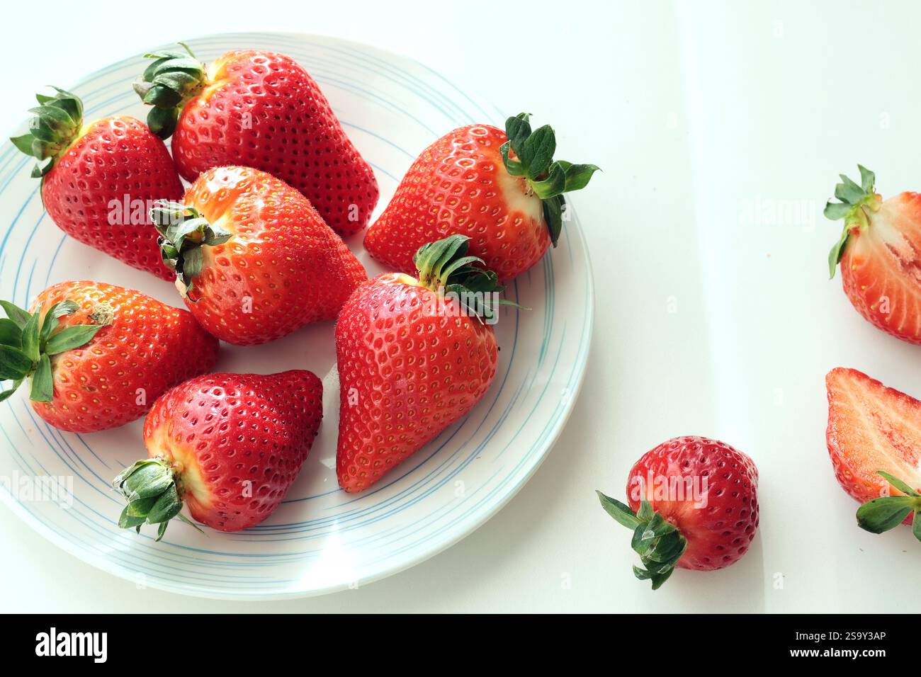 Gruppe von geschnittenen Erdbeeren aus dem Garten zu Hause auf Teller. Sonnentag. Umweltfreundliches reines Naturprodukt. Stockfoto