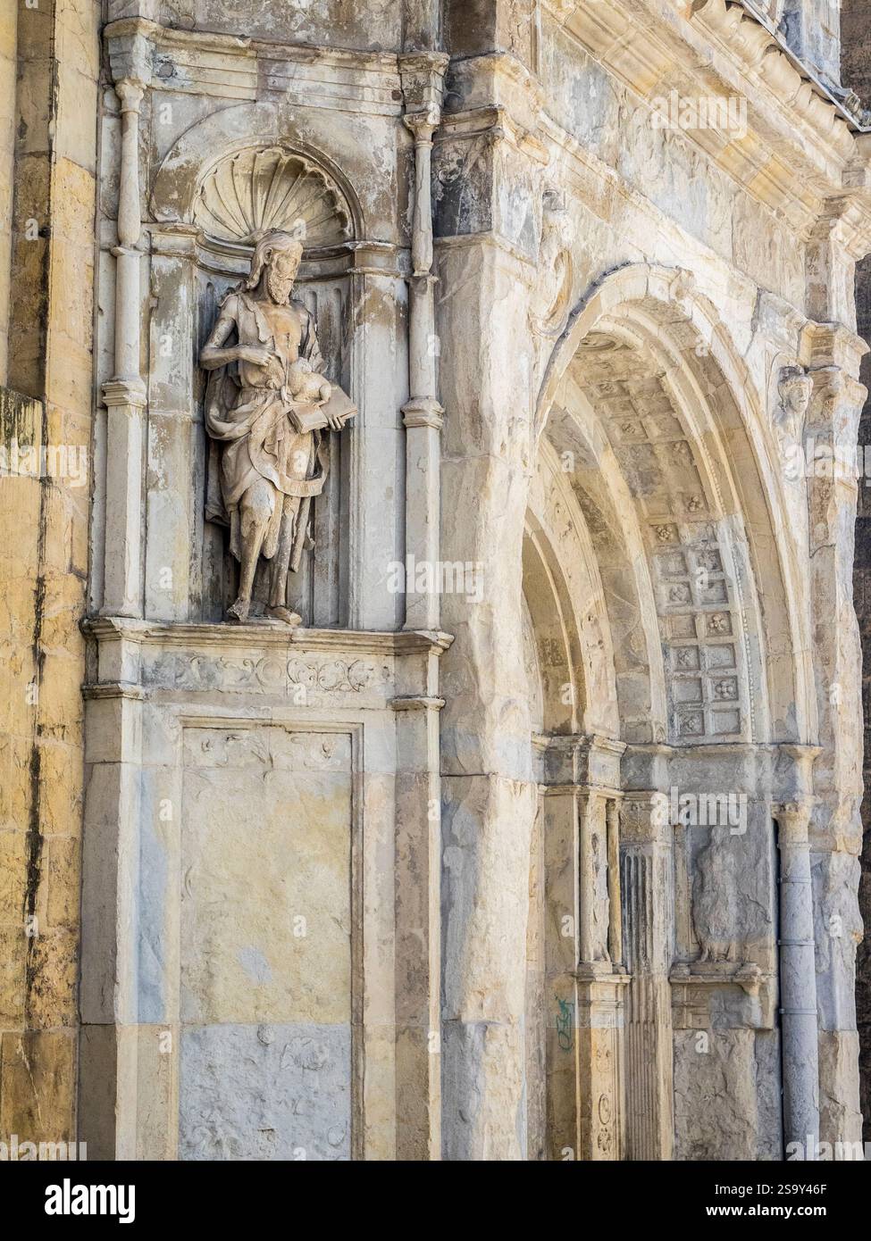 Geschnitzte Statue des heiligen Johannes des Täufers auf der Alten Kathedrale von Coimbra, einem romanischen römisch-katholischen Gebäude. Stockfoto