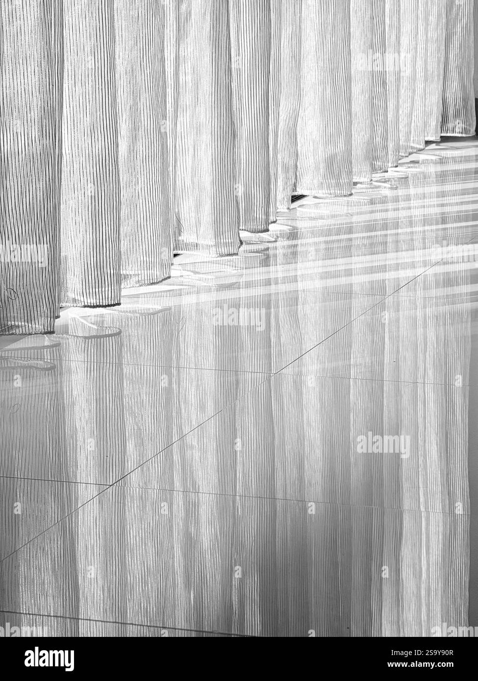 Licht und Schatten durch transparente Vorhänge Ein minimalistisches Schwarz-weiß-Foto, das das Zusammenspiel von Licht und Schatten zeigt, während sie durch s gehen Stockfoto