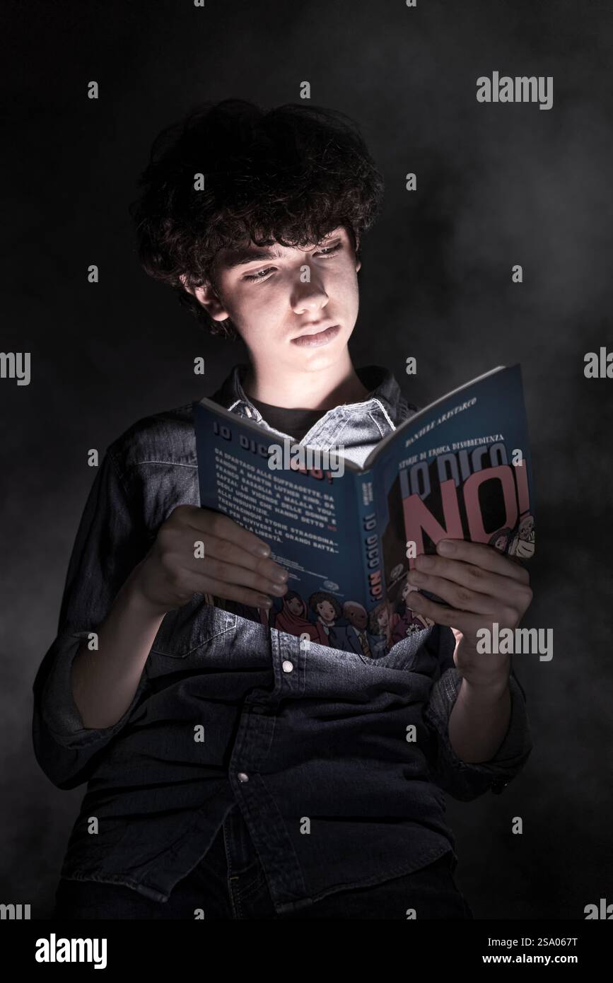 Lesen leuchtet auf: Ein Junge, der im Licht des Wissens verschlungen ist Stockfoto