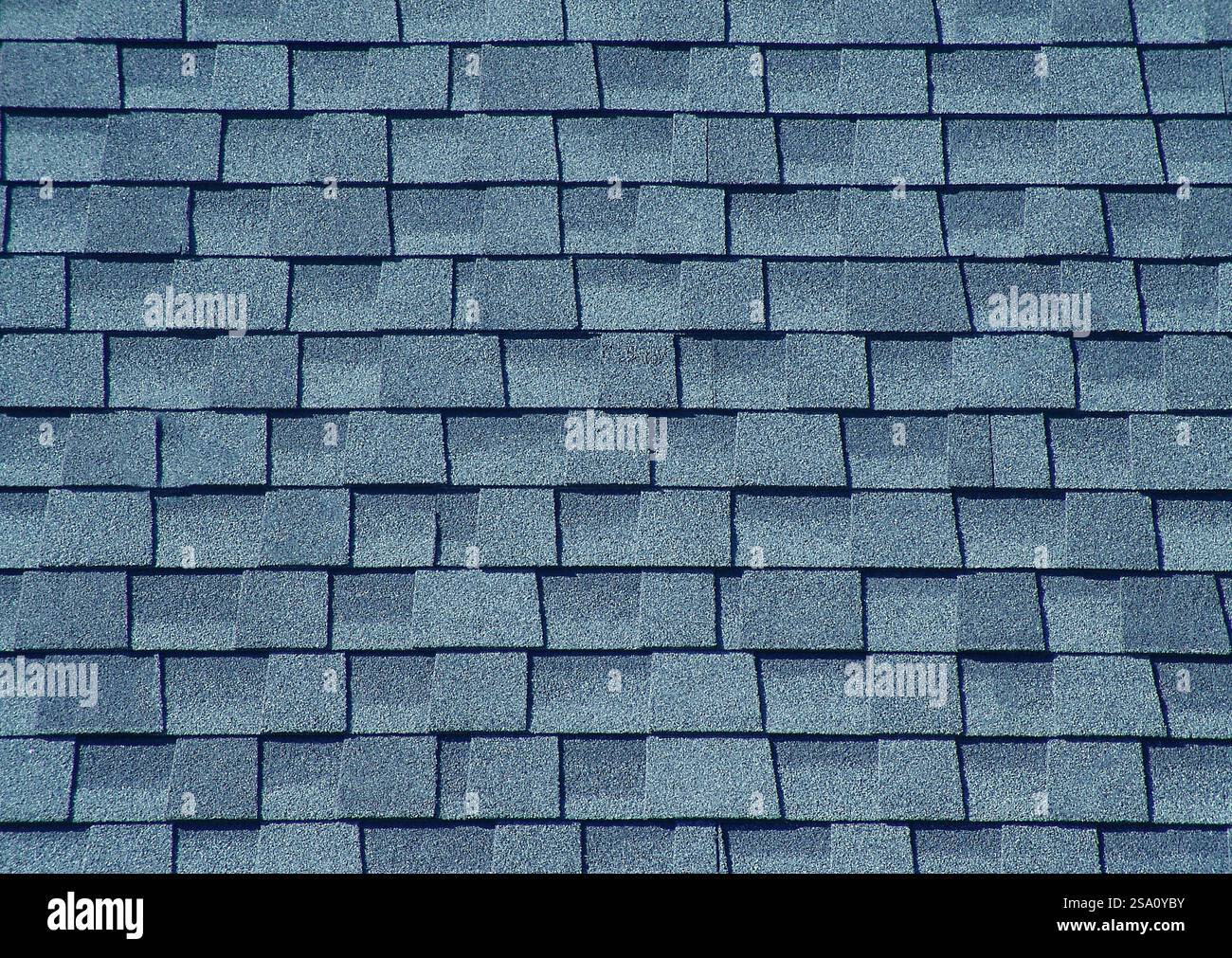 Moderne Asphaltschindeln, die ein Dach bedecken und ein strukturiertes Muster erzeugen Stockfoto
