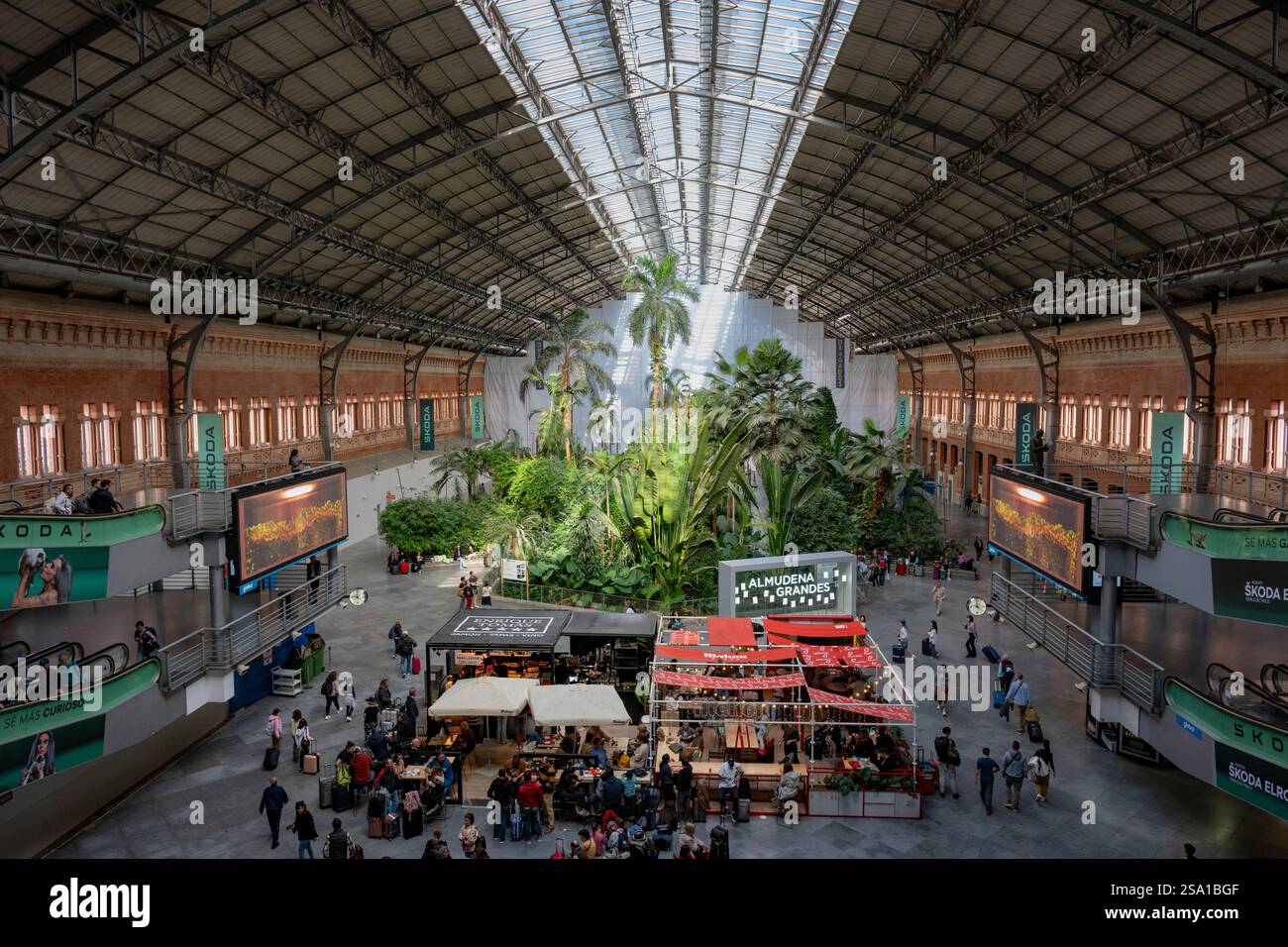 Leute, die zu Fuß essen und sich unterhalten, sind am Bahnhof Madrid Atocha, dem zentralen Terminal von Madrid, Spanien. Stockfoto