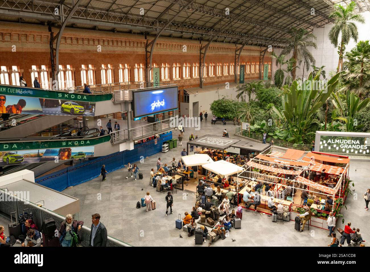 Leute, die zu Fuß essen und sich unterhalten, sind am Bahnhof Madrid Atocha, dem zentralen Terminal von Madrid, Spanien. Stockfoto
