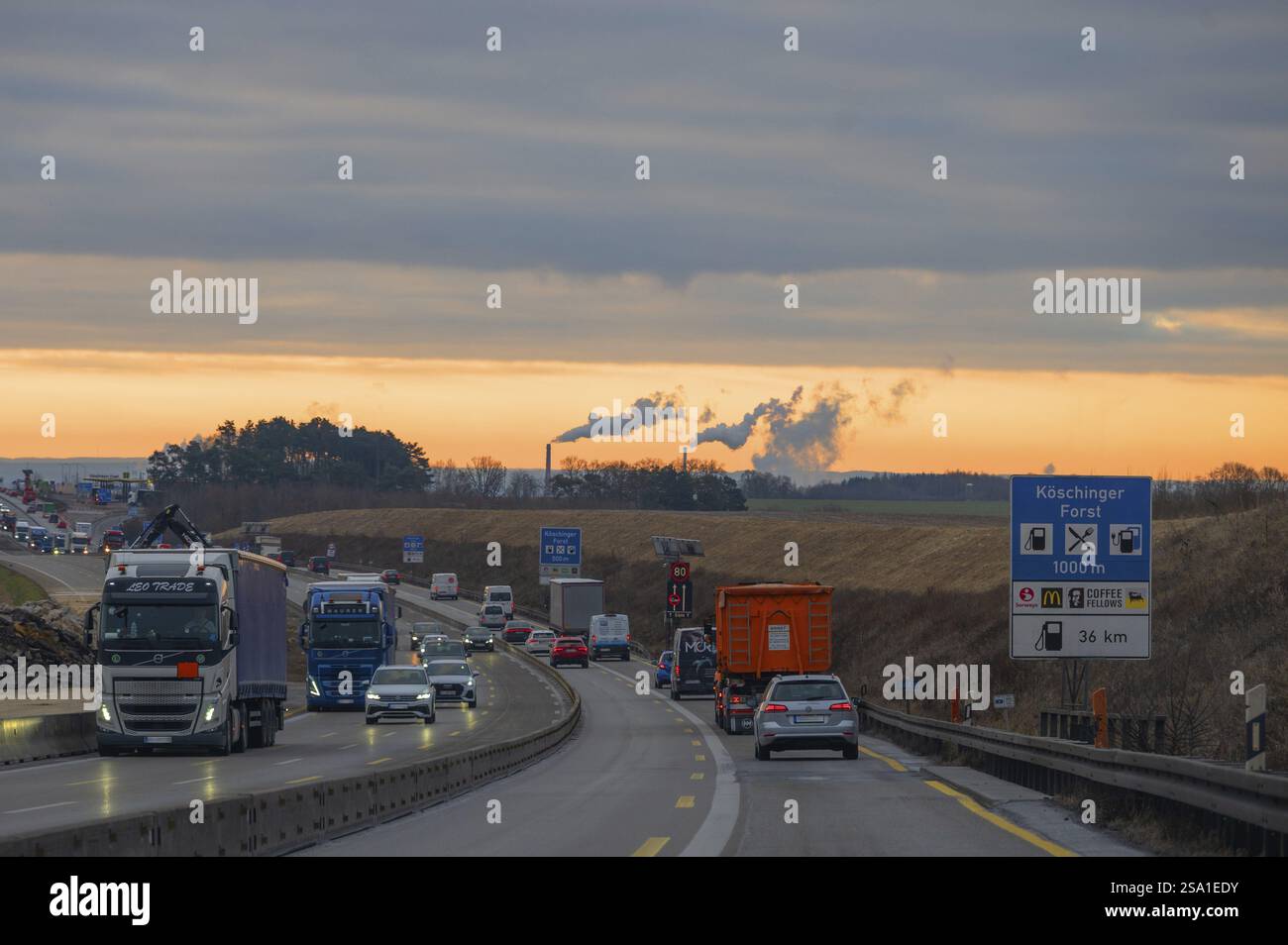Abendlicher Verkehr auf der Autobahn A9, Rauchschornsteine dahinter, Bayern, Deutschland, Europa Stockfoto
