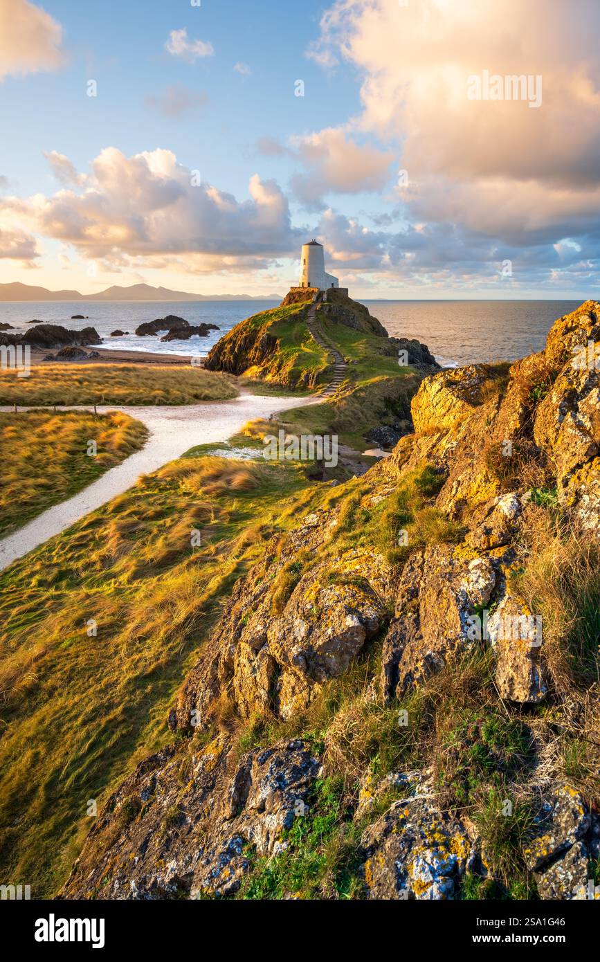 Golden Hour Sonnenaufgang am TWR Mawr Lighthouse mit dramatischem Blick auf die Berge von Snowdonia im Hintergrund. Anglesey, Nordwales, Großbritannien. Stockfoto