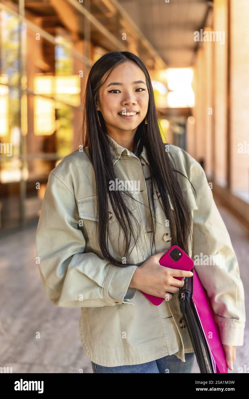 Vertikales Porträt einer glücklichen Schönheit und jungen chinesin auf dem Universitätscampus Stockfoto