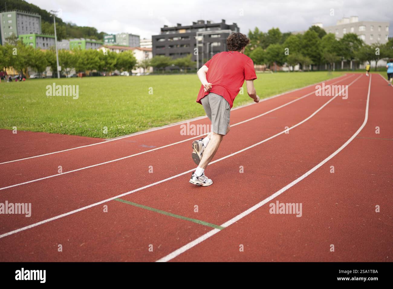Rückansicht eines kaukasischen jungen Läufers, der auf einer Laufstrecke sprintet Stockfoto