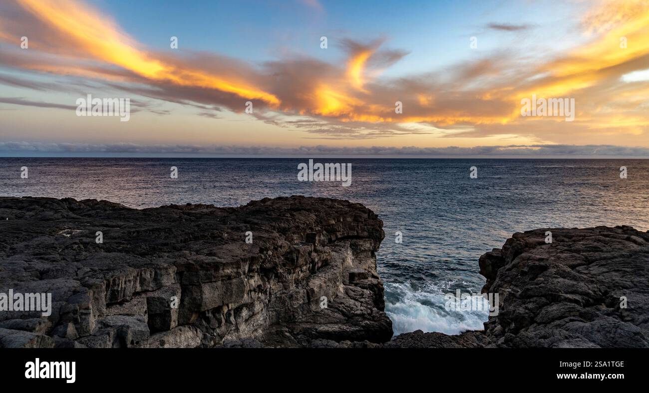 Eine atemberaubende Küstenlandschaft mit felsigen Klippen und einem riesigen Ozean unter einem farbenfrohen Sonnenuntergang Himmel mit schroffen Wolken. In El Hierro, den Kanarischen Inseln, Spai Stockfoto