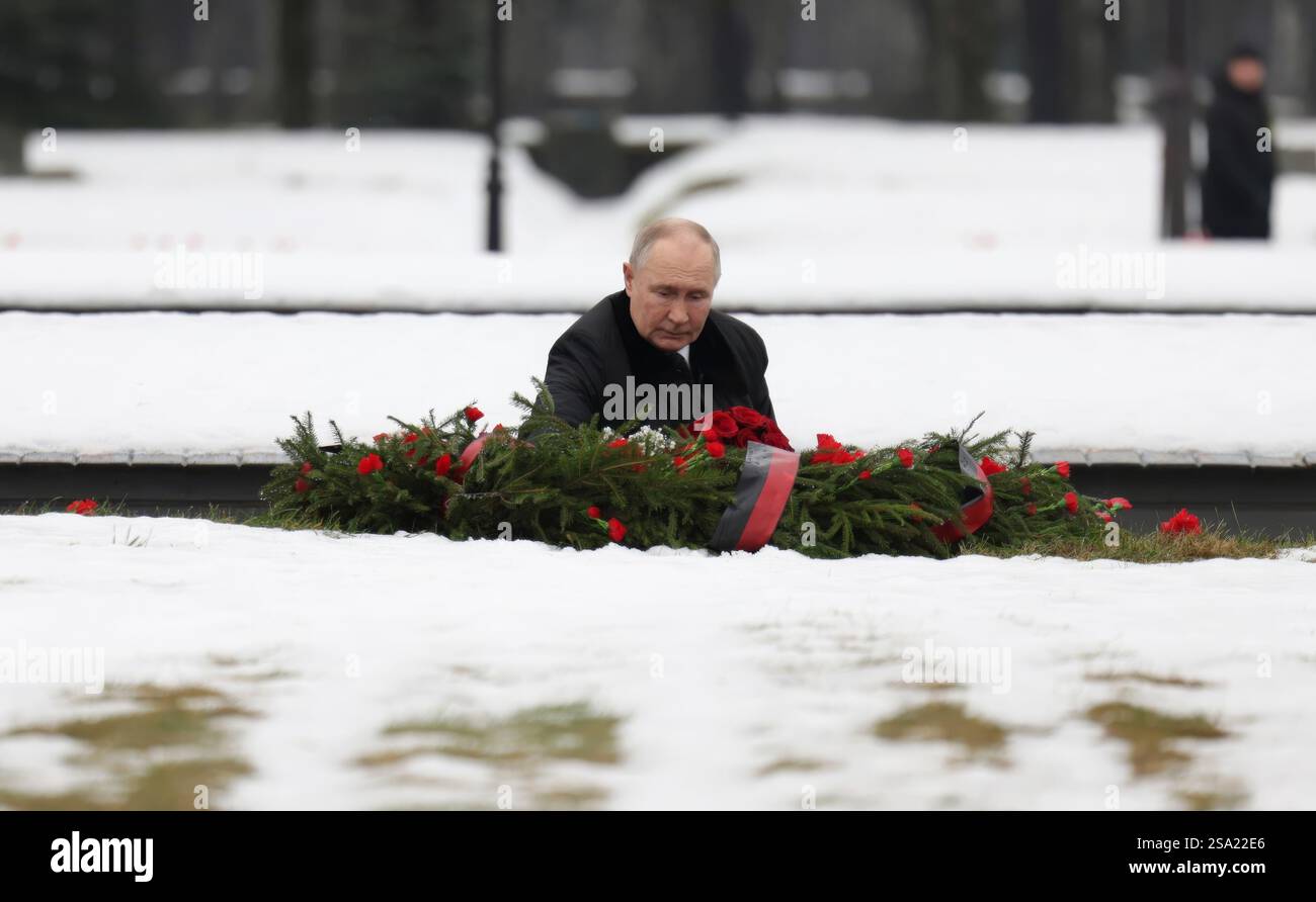 St. Petersburg, Russland. Januar 2025. Der russische Präsident Wladimir Putin legt während einer Zeremonie zum 81. Jahrestag der Befreiung Leningrads von der Nazi-Blockade auf dem Piskarjowskoje-Gedenkfriedhof am 27. Januar 2025 in St. Petersburg, Russland, einen Rosenstrauß auf ein Massengrab. Putin verlor seinen Bruder Viktor, der während der 872-tägigen Belagerung starb und der tödlichste und zerstörerischste in der Geschichte war. Quelle: Vyacheslav Prokofyev/Kreml Pool/Alamy Live News Stockfoto