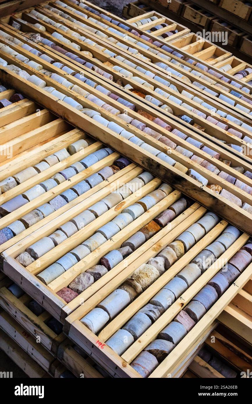 Ein Stapel von Holzkisten mit einer Vielzahl von farbigen Bohrhammerkern im Inneren. Die Felder sind übereinander gestapelt, wodurch ein Gefühl von Tiefe und Organisation entsteht Stockfoto