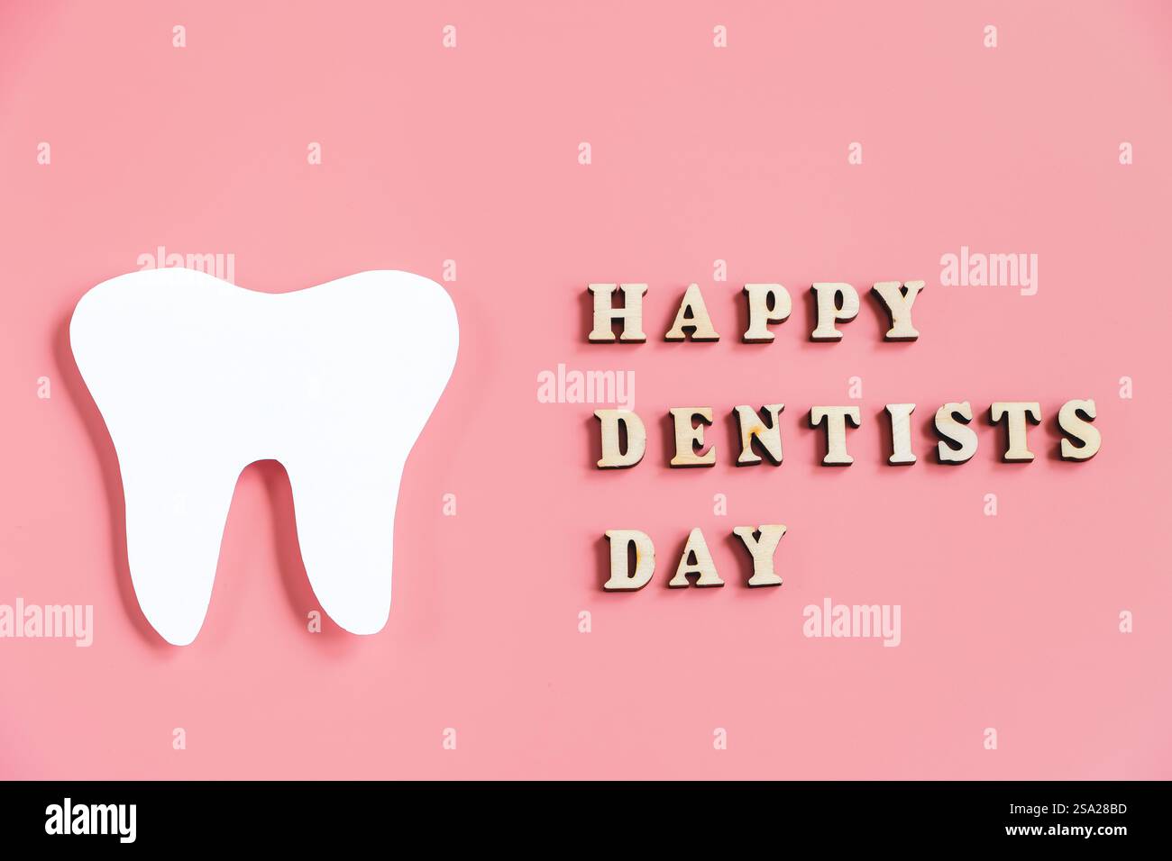 Papier geschnitten Nachbau von Zahn auf rosa Hintergrund. Alles gute zum Zahnarzttag. Zahnpflegekonzept. Stockfoto