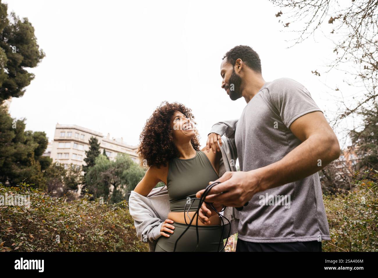 Ein Fitness-Trainer trainiert einen Kunden im Freien und betont dabei Gesundheit, Bewegung und positive Interaktion. Stockfoto