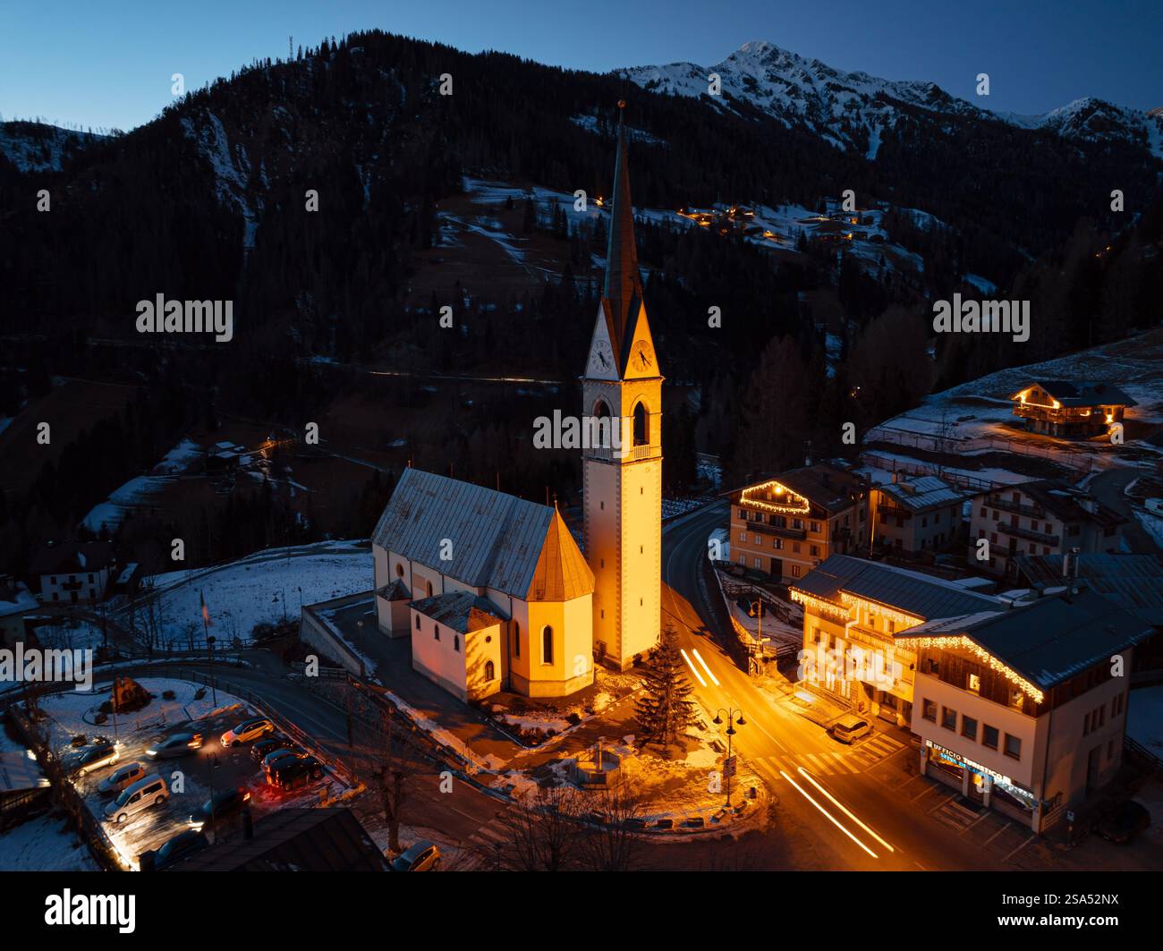 Aerial drone view of the San Lorenzo Church illuminated at night in the Selva di Cadore comune, in the Dolomites,Italy Stockfoto
