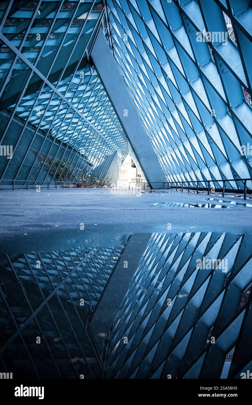 Eindrucksvolle Reflexionen der geometrischen Architektur der Seattle Public Library, die in einer Pfütze festgehalten wird, schaffen eine atemberaubende abstrakte urbane Szene. Stockfoto