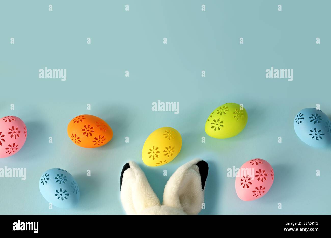 Osterhase mit bunten ostereiern auf blauem Hintergrund. Urlaubskonzept. Stockfoto