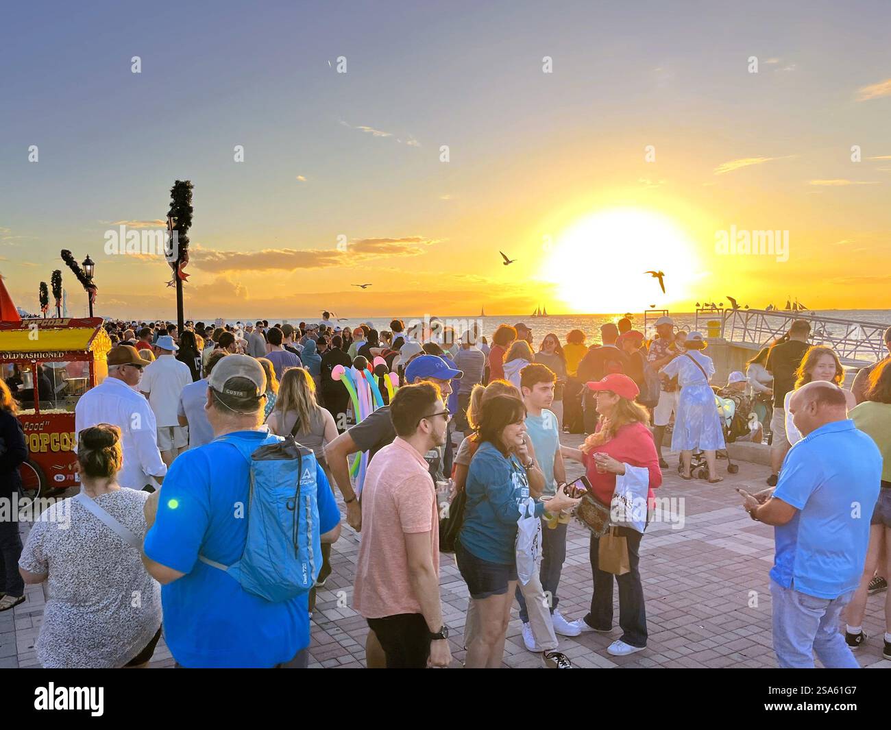 Key West, Florida, USA - 28. Dezember 2022: Hunderte von Touristen treffen sich jeden Abend am Mallory Square in Key West, Florida, um den brillanten Sonnenuntergang zu beobachten. Stockfoto