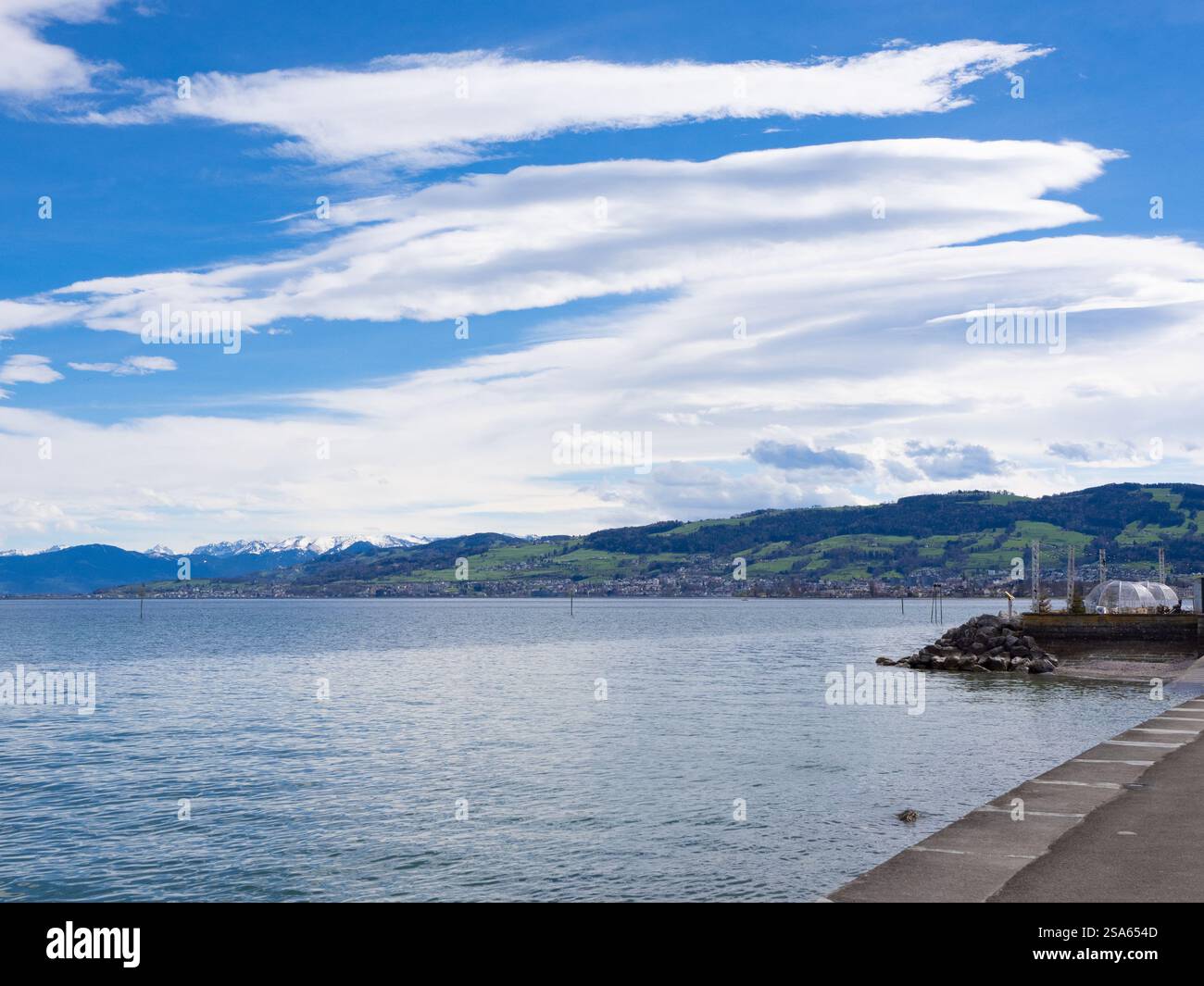 Arbon, Schweiz - 29. März 2024: Am Bodenseeufer vor den Alpen mit typischen Föhnwolken Stockfoto