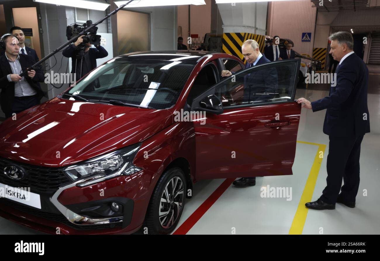 Togliatti, Russland. Januar 2025. Der russische Präsident Wladimir Putin, links, zeigt den Prototyp eines Lada Iskra-Fahrzeugs von AvtoVAZ-Präsident Maxim Sokolov, rechts, während einer Tour durch die Automobilproduktion im Werk Tolyatti am 28. Januar 2025 in Togliatti, Oblast Samara, Russland. Quelle: Vyacheslav Prokofyev/Kreml Pool/Alamy Live News Stockfoto