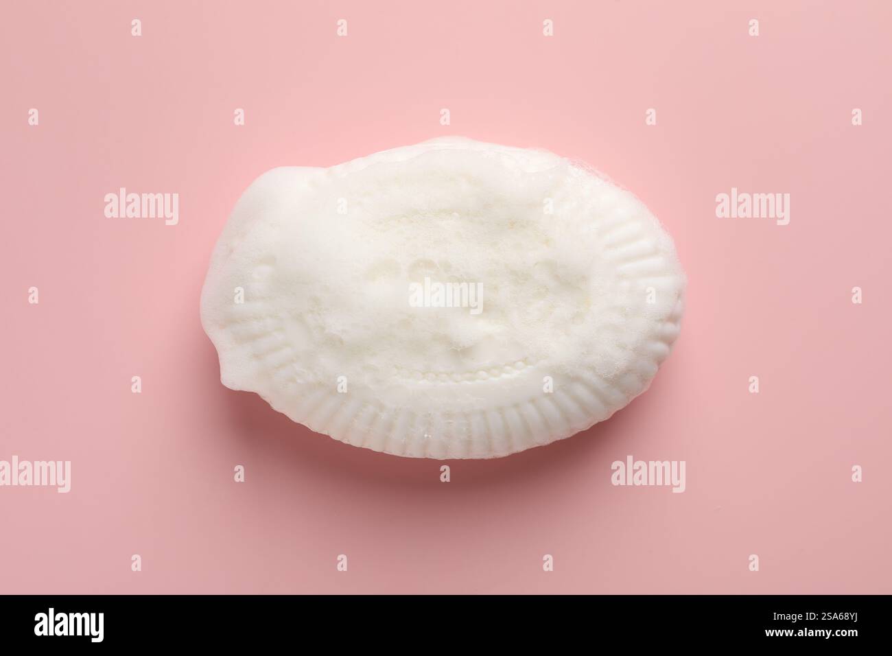 Seifenleiste mit Schaum auf hellrosa Hintergrund, Draufsicht Stockfoto