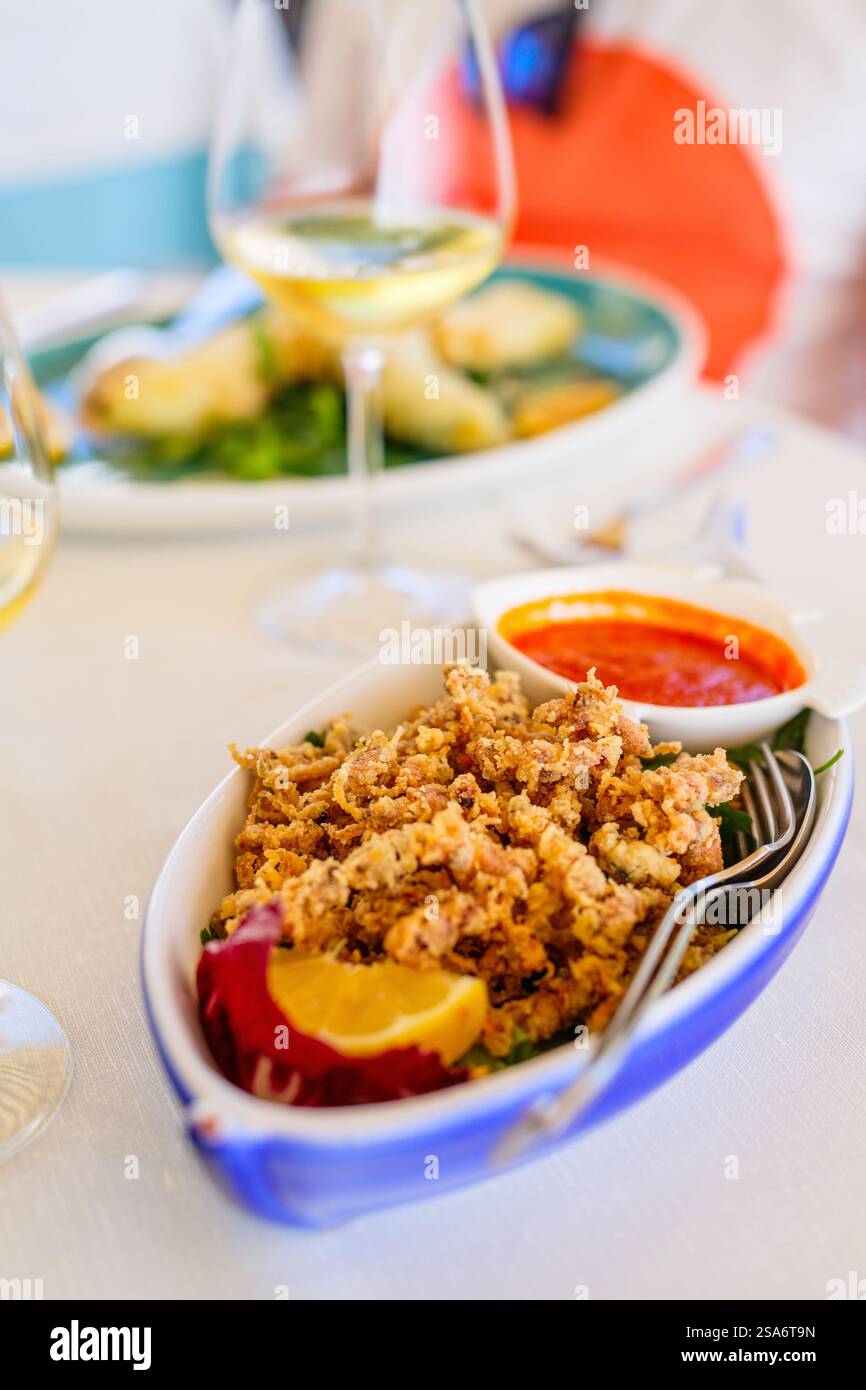 Köstliche frittierte Meeresfrüchte-Vorspeise mit Weißwein zum Mittagessen im Restaurant Stockfoto