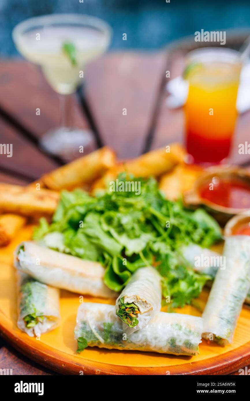 Traditionelle vietnamesische Brötchen mit anderen kleinen Häppchen und tropischen Cocktails Stockfoto