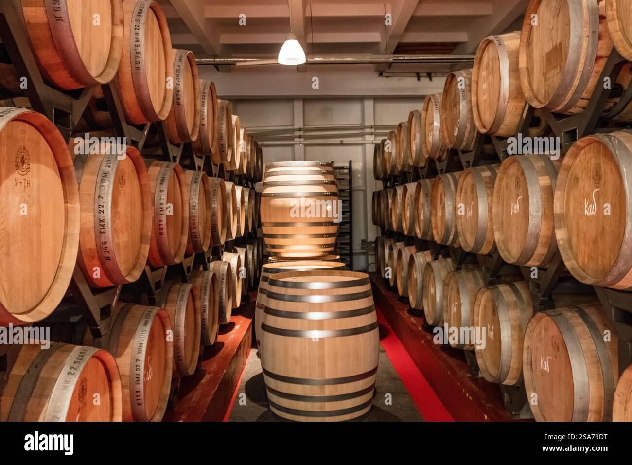Eine Reihe von Fässern gefüllt mit Wein. Die Fässer sind übereinander gestapelt. Die Fässer sind braun und der Wein im Inneren ist wahrscheinlich gereift Stockfoto