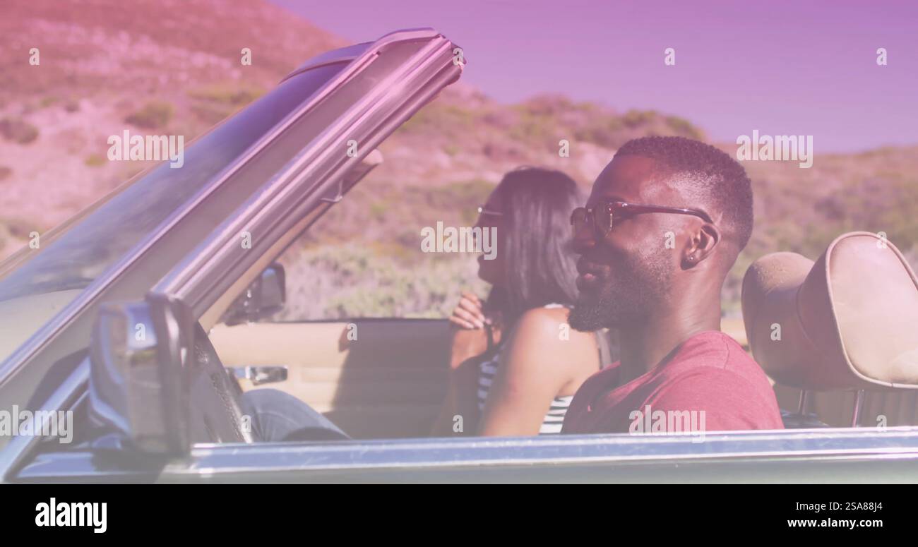 Bild von hellem Schatten über zweirassigem Paar, das am Meer Auto fährt Stockfoto