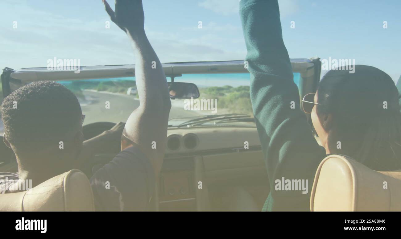 Bild von hellem Schatten über zweirassigem Paar, das am Meer Auto fährt Stockfoto