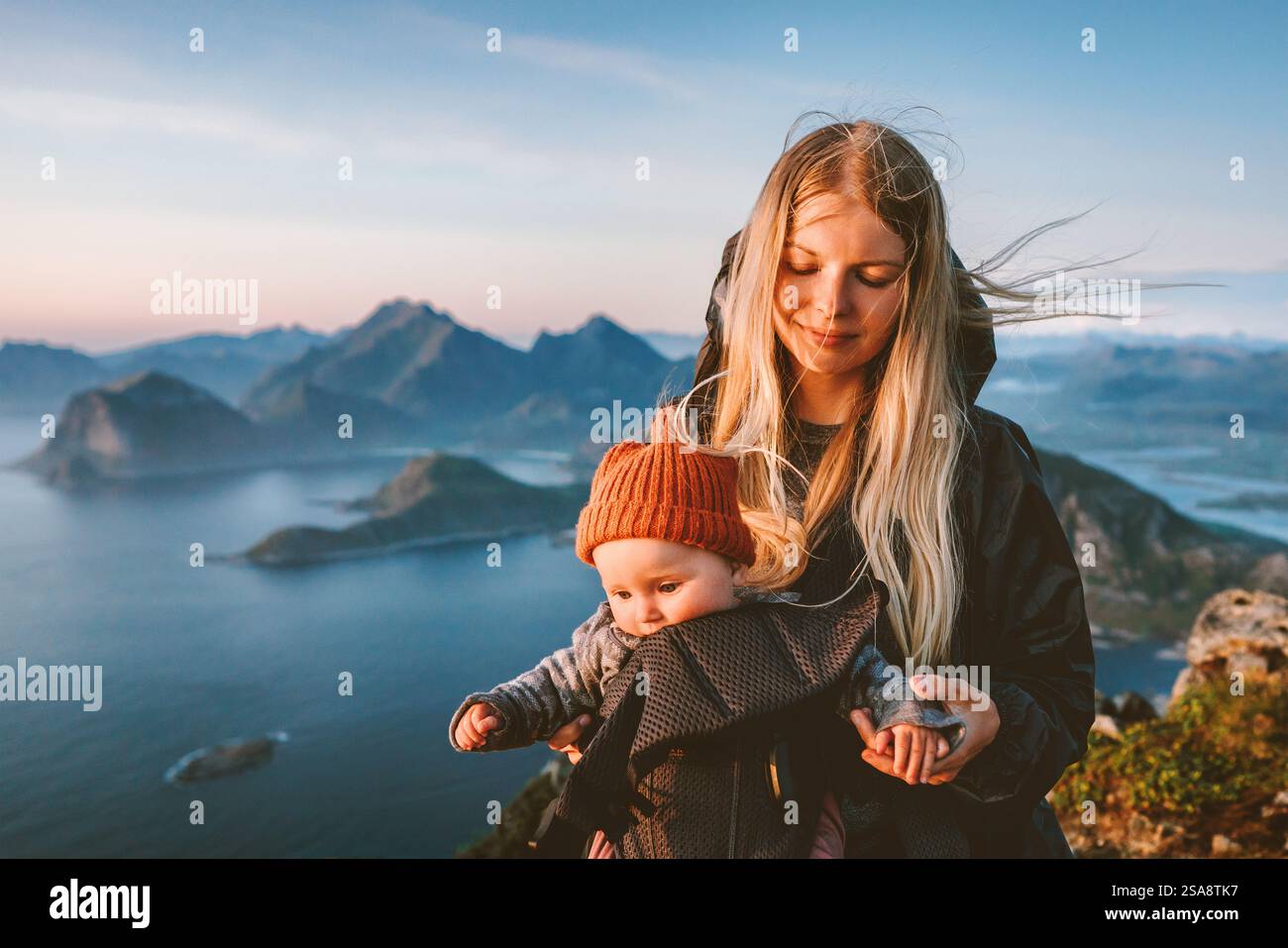 Mutter Wandern mit Babytrage gesunder Lebensstil im Freien Familie Zeitreise in Norwegen Sommerurlaub skandinavische Frau mit Kind in den Bergen von Stockfoto