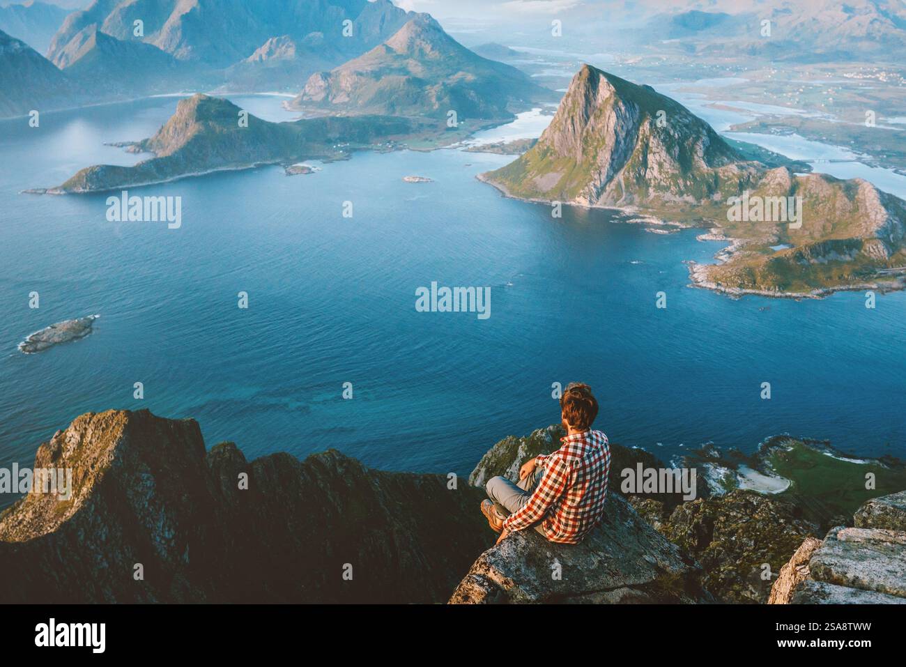 Mann Reisende sitzend am Rande der Bergklippe in Norwegen allein Wandern in den Bergen im Freien aktiv gesunde Lebensweise Abenteuer Urlaub Tourist Ex Stockfoto