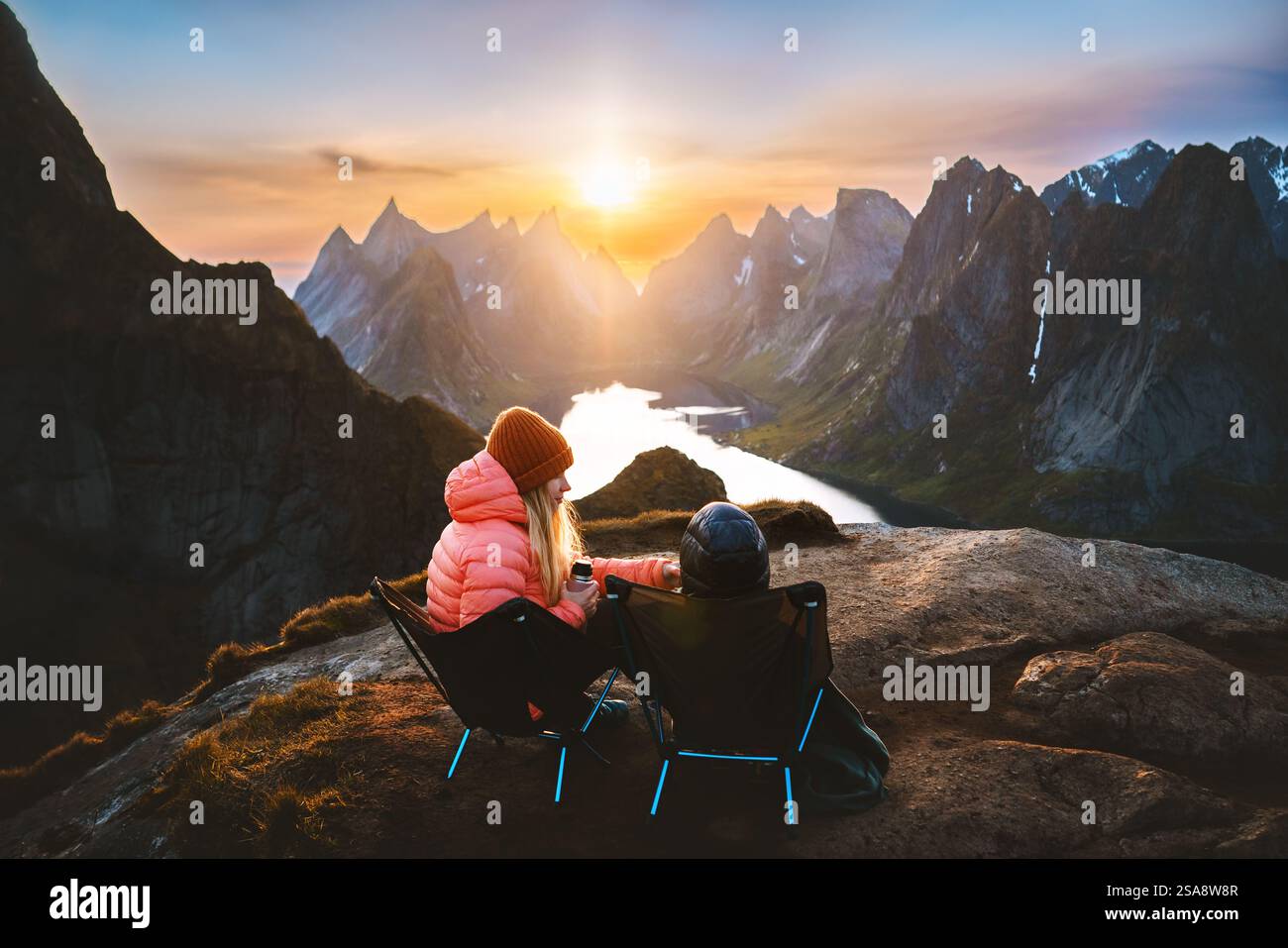 Familie Picknick in Norwegen Mutter und Kind Entspannung in den Bergen Reise Urlaub im Freien Frau mit Kind in Campingstühlen genießen Sonnenuntergang Lofoten islan Stockfoto