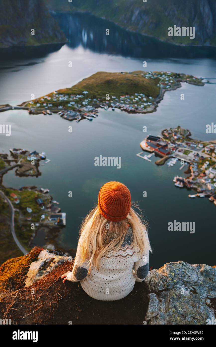 Frau, die auf den Lofoten reist Mädchen sitzt auf dem Berg Reinebringen in Norwegen Aktivurlaub Alleinreisender trägt skandinavischen Pullover im Freien Stockfoto