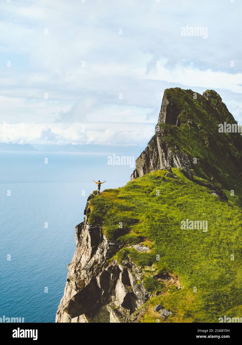 Mann Abenteurer alleine in Norwegen unterwegs mit Blick auf die Klippe des Berges über dem Meer, touristische Wanderungen Outdoor aktiv gesunde Lebensstil Abenteuer Stockfoto