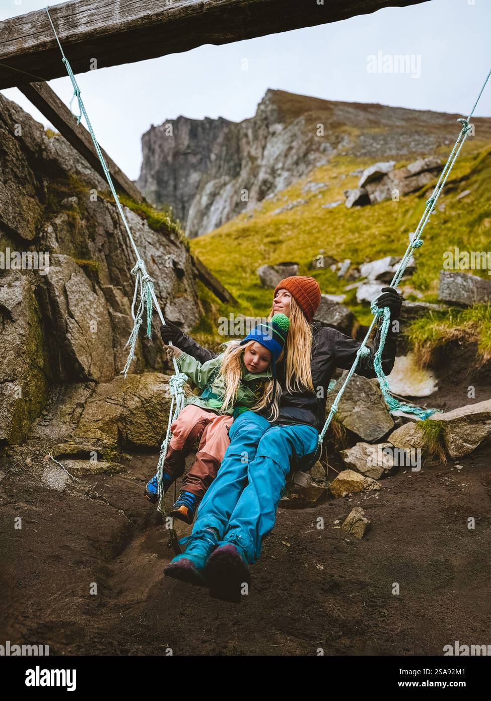 Familie Mutter mit Tochter Kind schwingt auf Schaukel und hat Spaß im Freien zusammen reisen Aktivurlaub in Norwegen Kind Mädchen und Mutter genießen Tour Stockfoto
