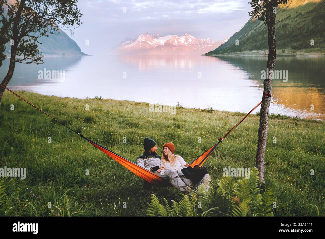 Glückliches Paar, das in einer Hängematte im Freien chillt, Mann und Frau, die zusammen reisen, Familienleben, Sommerurlaub, fröhliche Frau und Ehemann Romanti Stockfoto