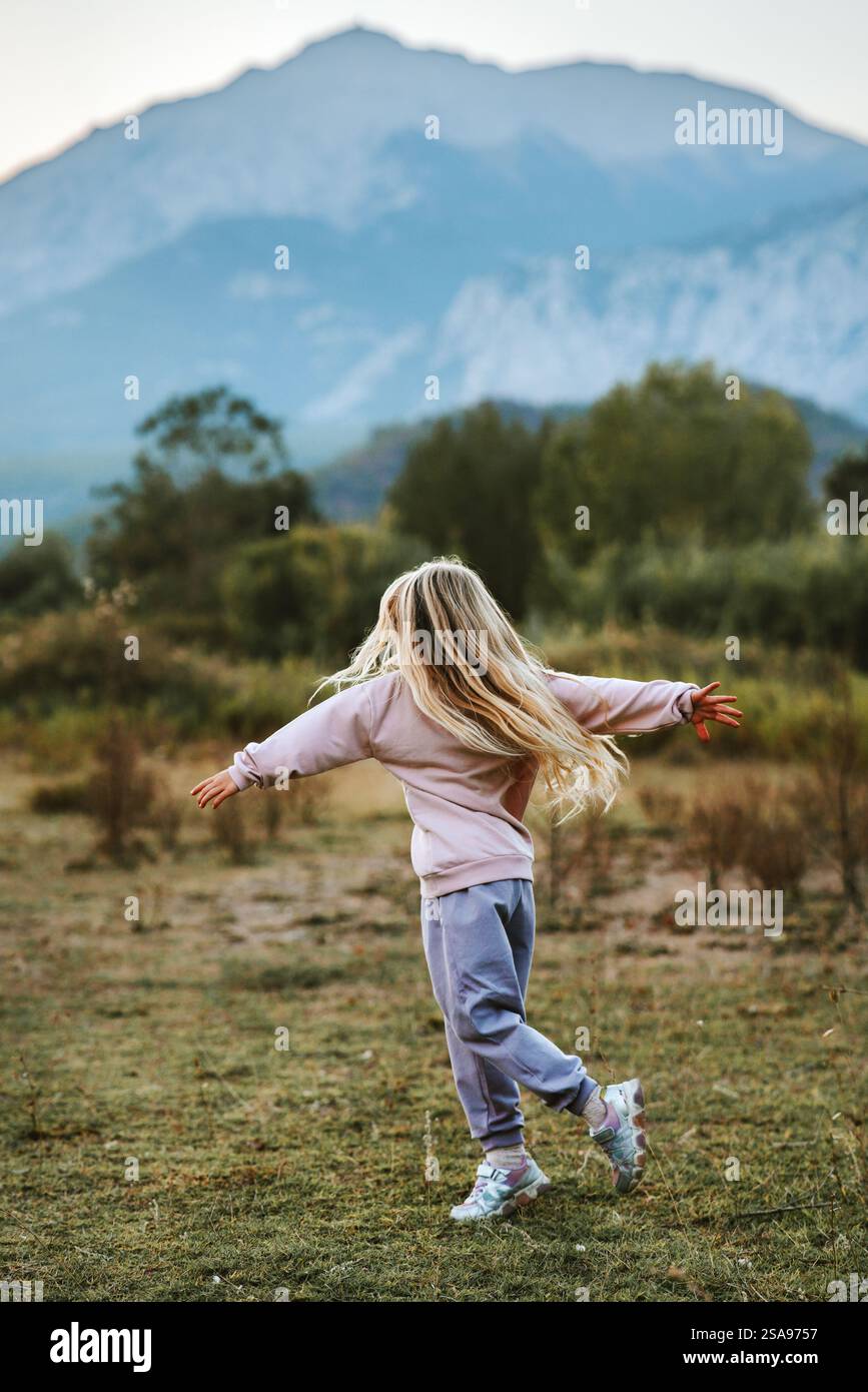 Mädchen Kind, das im Freien läuft und spielt, Familie aktiv Reisen Lifestyle Urlaub, 5 Jahre altes Kind mit langen blonden Haaren, die Berge erkunden und die Berge erkunden Stockfoto