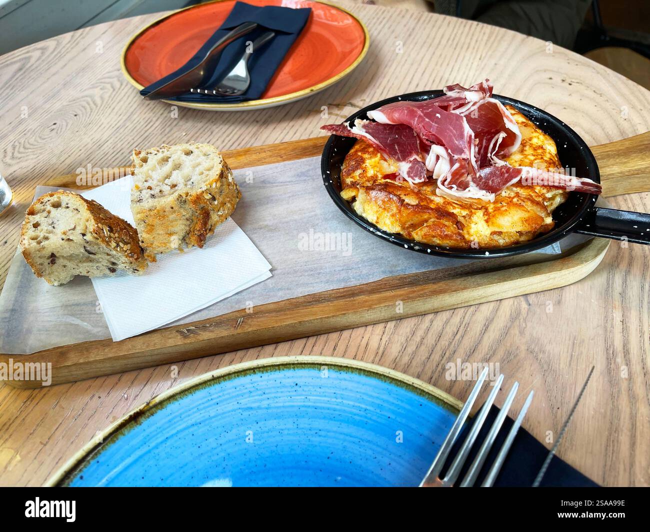 Spanisches Omelett mit iberischem Schinken. Spanien. - Smartphone-aufgenommenes Stockfoto