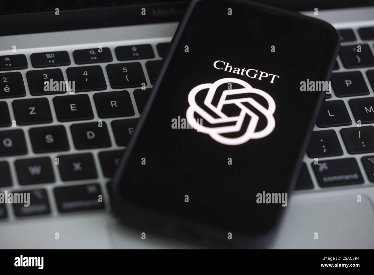 OpenAI-Software ChatGPT-Anwendung auf einem Mobiltelefon über einer Computertastatur Stockfoto