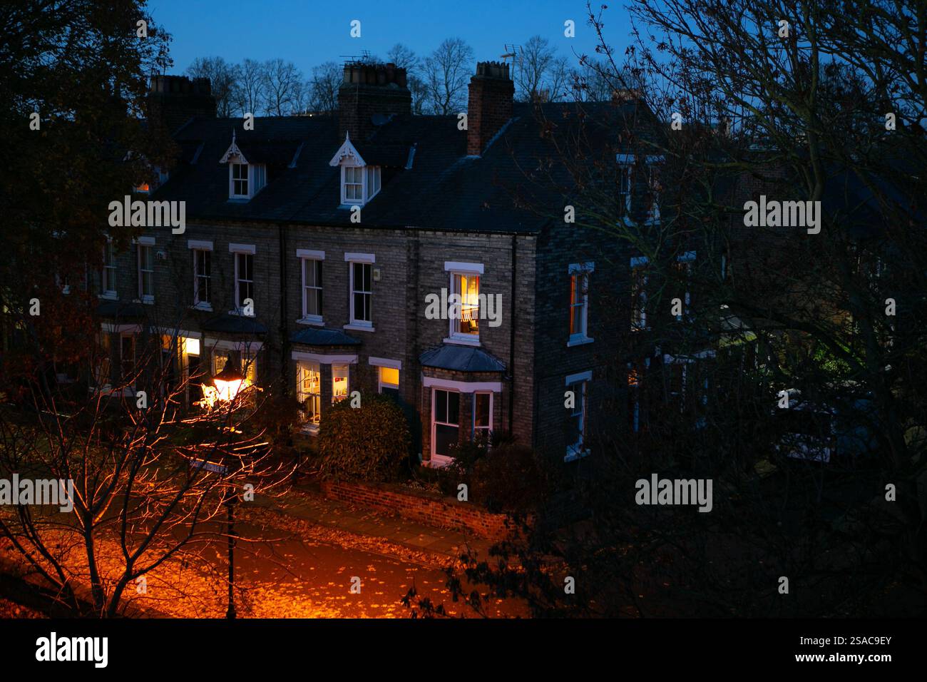 Dämmerung und Lichter und Heizung werden in einer Terrassenstraße in York, North Yorkshire, eingeschaltet, da die Treibstoffkosten im Winter steigen, wenn das Winterwetter das Wetter erreicht Stockfoto