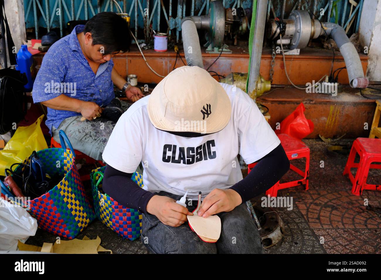Schuhwerkstatt auf der Straße. Manuelle Arbeit. Ho-Chi-Minh-Stadt. Vietnam. Stockfoto